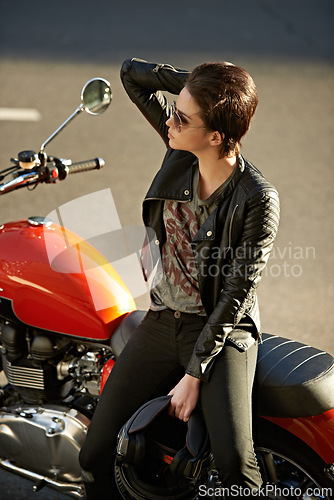 Image of Motorcycle, street and woman in city with sunglasses for travel, transport or road trip as rebel. Fashion, leather and model with attitude on classic or vintage bike for transportation or journey