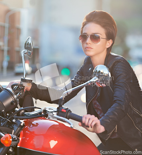 Image of Motorcycle, power and woman in city with sunglasses for travel, transport or road trip as rebel. Fashion, street and model in leather jacket on classic or vintage bike for transportation or journey