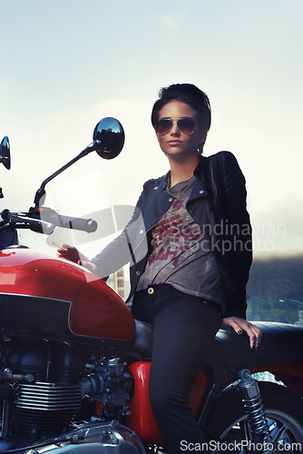 Image of Motorcycle, leather and rebel woman in city with sunglasses for travel, transport or road trip. Fashion, evening and person with attitude on classic or vintage bike for transportation or journey