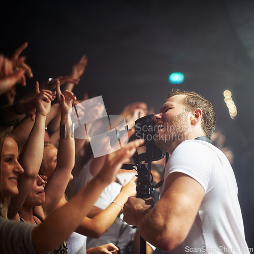 Image of Man, concert and camera for photography and artistic culture with fun nightlife at club. Entertainment, male person and photograph or filming happy crowd at musical performance in nightclub or party