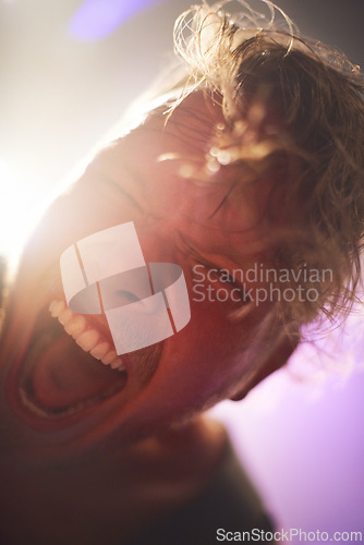 Image of Portrait, closeup and man screaming for rockstar performance at concert for entertainment at night. Culture, yelling and face of musician male person with energy at festival for artistic expression