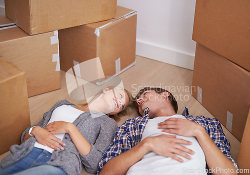 Image of Couple, floor and moving or boxes for new home packing or real estate property to relax in marriage and apartment. Man, woman and rest or investment loan or mortgage for relocation, rent or buy