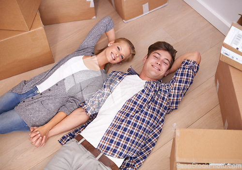 Image of Man, woman and portrait and floor with moving boxes or relax or real estate investing as new beginning, relocation or marriage. Couple, happy and rest bonding in apartment or rent, above or packing