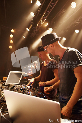 Image of Electric, music and dj at stage for performance with sound board and laptop for production in concert. Audio, equipment and people in club with creative show mixing on turntable with techno at rave