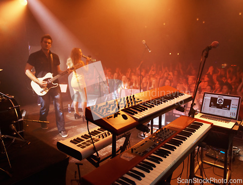 Image of Concert, band and keyboard at stage for performance with singer and musician on guitar. Music festival, crowd and people with talent playing for audience in theater at night with spotlight and energy