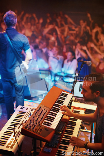 Image of Band, performance and fans at stage for concert with person on piano and guitar. Music festival, crowd and people with talent playing for audience in theater or club at night with musician in light