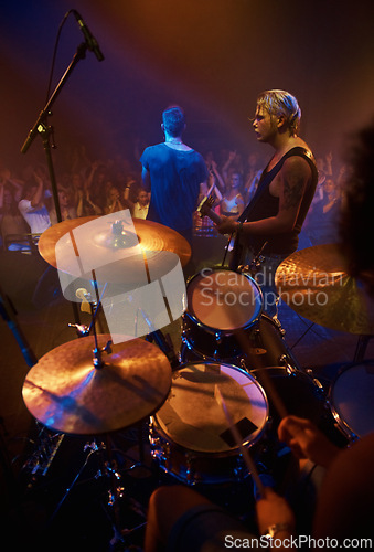 Image of Drummer, musician and band at stage for concert, performance and crowd at night. Music festival, talent and people playing for audience in theater or club with instrument, light and creative energy