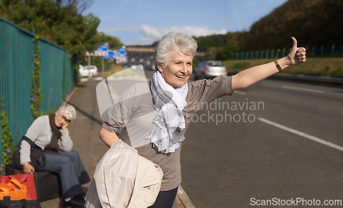 Image of Women, road and hitch hiker for lift in retirement, travel and friends in city with bags for adventure. Senior ladies, thumbs up and happy by roadside with hand gesture and stop transport to commute