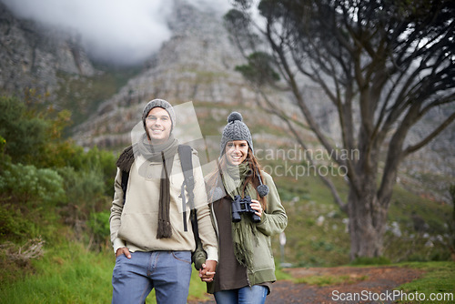 Image of Couple, portrait and hiking on mountain or holding hands with travel, adventure or holiday for experience or love. Man, woman and trekking outdoor on trail for cardio, exercise or happy and binocular