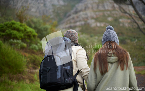 Image of Outdoor, hiking and couple in mountain, holding hands and walking with backpack, nature and bonding together. Forest, adventure and trekking in path, field and exercise for fitness and travel