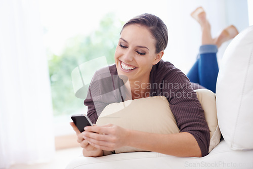 Image of Happy, woman and phone for typing on sofa, scroll social media and reading chat notification in lounge at home. Lady, relaxing and download digital app, mobile games and search contact on smartphone