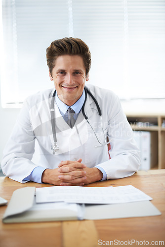 Image of Happy, confident and portrait of doctor in office for consultation with positive and good attitude. Smile, career and professional young male healthcare worker with pride at desk in medical clinic.