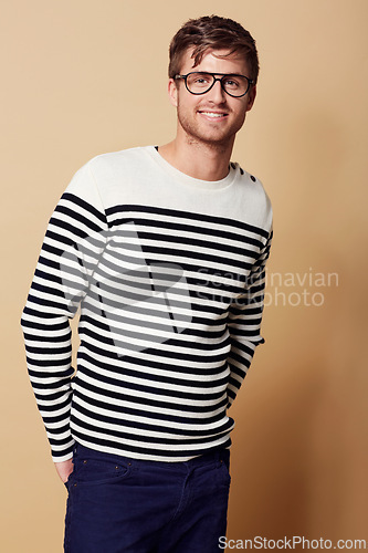 Image of Fashion, glasses and portrait of man in studio in trendy, stylish and casual clothes on beige background. Happy, attractive and person with stripe style for positive attitude, pride and confidence