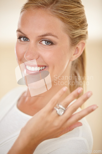 Image of Woman, portrait and wedding ring with engagement announcement and diamond. Marriage, female person and showing hand with jewelry band, proposal and fiance with a smile and happy from commitment