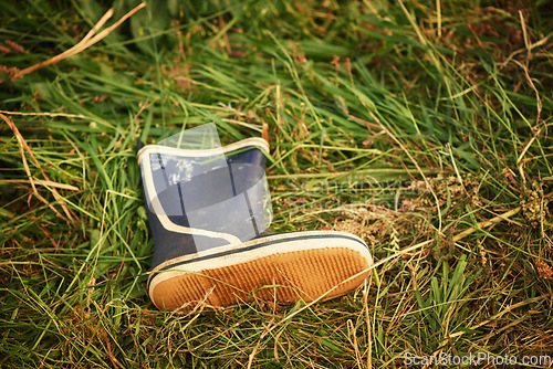 Image of Boot, grass and outdoor with nature, day and lost with environment, sunshine and countryside. Outside, empty and single shoe with footwear, ground and missing with field and abandon with summer