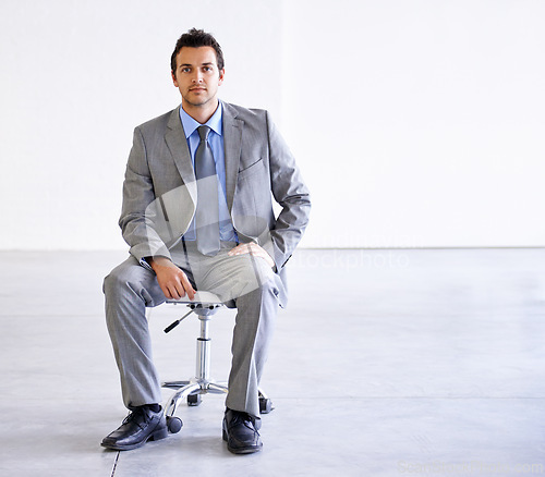 Image of Portrait, serious and business man on chair in office, workplace or corporate company on mockup space. Confident professional, employee and worker, lawyer and attorney in suit for career in Spain