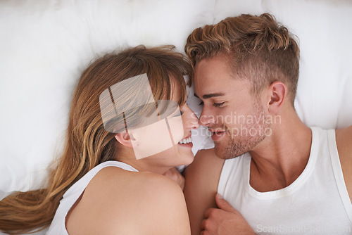 Image of Couple, love and relaxing in bed on weekend, happy and bonding or care in relationship at home. People, loyalty and commitment to marriage in bedroom, smiling and romance or comfortable and lazy