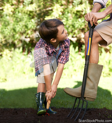 Image of Child, father and help with gardening in nature using tools for agriculture conservation and ecology education. Soil, compost and a man teaching boy kid to plant with fork for organic earth support