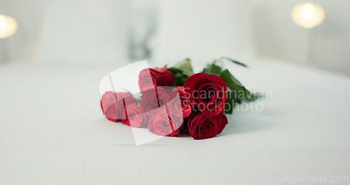 Image of Romance, flowers and roses in bedroom for love on valentines day, anniversary celebration and honeymoon. Red rose, bouquet and closeup of florals on bed for romantic date, occasion and luxury in home