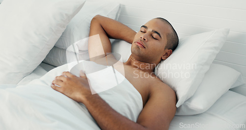 Image of Man, eyes closed and sleeping in bed at home, peace and dreaming or relax on sunday morning. Male person, comfortable and blanket for resting, lazy and house nap on soft bedding and calm on weekend