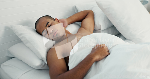 Image of Man, resting and sleeping in bed at home, peace and dreaming or relax on sunday morning. Male person, comfortable and blanket for stress relief, lazy and house nap on soft bedding and calm on weekend