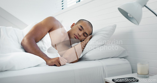 Image of Man, eyes closed and sleeping in bed at home, peace and dreaming or relax on sunday morning. Male person, comfortable and blanket for resting, lazy and house nap on soft bedding and calm on weekend