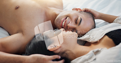 Image of Happy couple, talking in bed with love, intimacy and romance at home for relationship, sex and bonding. Young people, woman and man relax in bedroom with gentle touch and kiss for valentines day