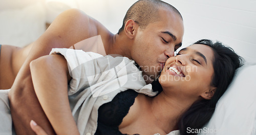 Image of Happy couple, hug in bed and love with intimacy and romance at home for relationship, sex and bonding. Young people, woman and man relax in bedroom, cuddle and laughing with kiss and talking together