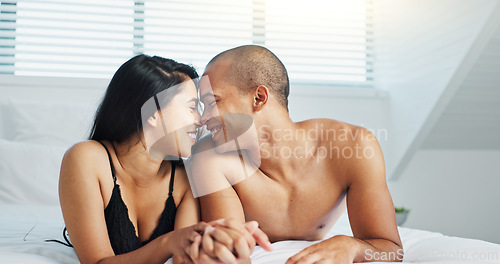 Image of Happy couple, relax and kissing on bed for intimacy, morning romance or love in embrace, trust or care at home. Young man and woman smile lying in bedroom for passion or bonding together at house