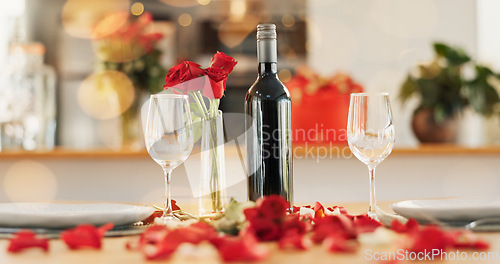 Image of Wine, flowers and romance on valentines day for celebration of love, anniversary or honeymoon in still life. Glass, dinner and elegant date in dining room of home for event, milestone or occasion