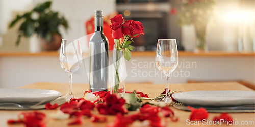 Image of Wine, flowers and romance on valentines day for celebration of love, anniversary or honeymoon in still life. Glass, dinner and elegant date in dining room of home for event, milestone or occasion