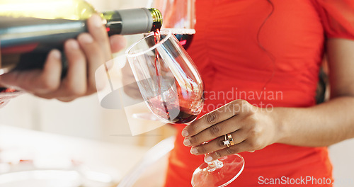 Image of Couple, hands and bottle of red wine for celebration of love, romance and valentines day on their anniversary. People or lover on date with glasses, drinks and alcohol for toast, success and luxury