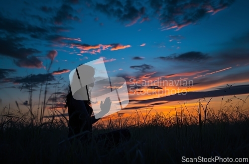 Image of Woman Kneeling in Field at Sunset - Serene and Contemplative Moment Captured in Nature