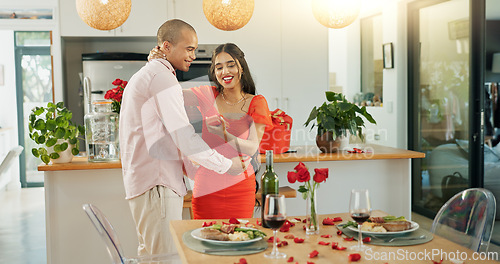 Image of Happy couple, hug and anniversary surprise with kiss for date, valentines day or romantic gift at home. Young man and woman smile in hug for dinner, passion or bonding romance by table at house