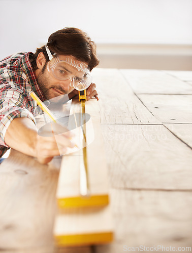 Image of Man, wood and carpenter with idea, planning and building for home improvement, remodeling and renovation. Handyman, craftsman and contractor with maintenance, wood and skill for measurement or repair