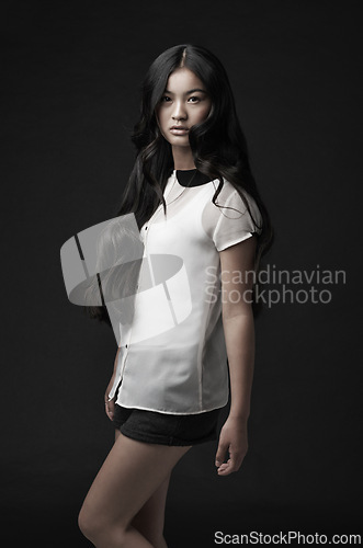 Image of Woman, portrait and fashion with confidence in studio or dark aesthetic or clothing style, black background or mockup space. Asian person, model and face or serious or Japanese beauty, cool or outfit