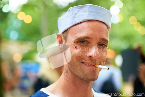 Image of Portrait, smile and man with a cigarette, music festival and sailor outfit with fun and costume. Face, person and guy with tobacco, outdoor or nicotine with concert or happy with culture or bad habit