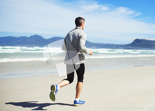 Image of Back, space or man at beach running for exercise, training or outdoor workout at sea for fitness. Sports person, mature runner or healthy athlete on sand for cardio endurance, wellness or mockup