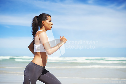 Image of Fitness, Indian or woman on beach running for exercise, training or outdoor workout at sea. Sports person, runner or healthy athlete in nature for cardio endurance, wellness or challenge on sand