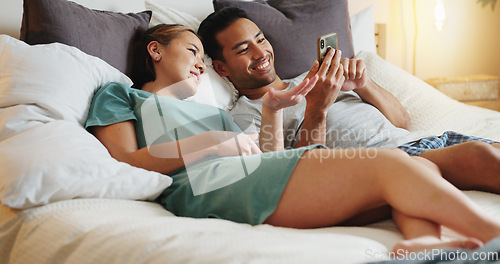 Image of Couple in bed, social media with smartphone and smile at funny online meme posts in bedroom together. Happy man with phone, woman smiling with happiness at home and relax together on weekend morning