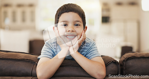 Image of Happy, cute and face of a child on the sofa for playing, relax and weekend fun. Smile, youth and portrait of a little boy kid with an adorable expression, charming and on vacation on the couch