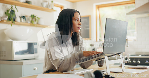 Image of Laptop, documents and remote work with a woman entrepreneur in the kitchen of her home for small business. Computer, report and a young female freelance employee working on a startup from her house