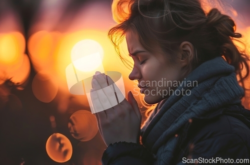 Image of Woman Praying in Front of the Sun