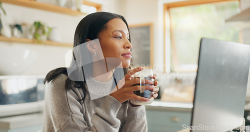 Image of Laptop, coffee and freelance with a woman entrepreneur in the kitchen of her home for small business. Computer, report or email with a young female employee remote working on a startup from her house