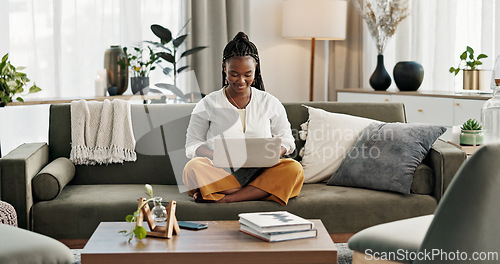 Image of Black woman on sofa, smile and typing on laptop for remote work, social media or blog post research in home. Happy girl on couch with computer checking email, website or online chat in living room.