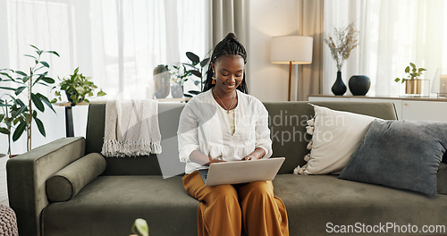 Image of Black woman on sofa, smile and typing on laptop for remote work, social media or blog post research in home. Happy girl on sofa with computer checking email, website or online chat in living room.