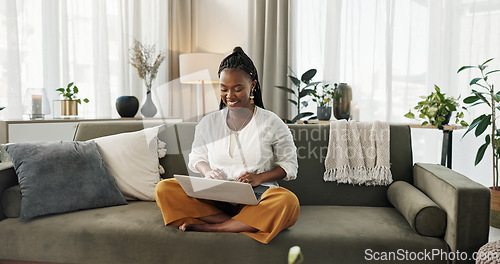 Image of Black woman on sofa, smile and typing on laptop for remote work, social media or blog post research in home. Happy girl on couch with computer checking email, website or online chat in living room.