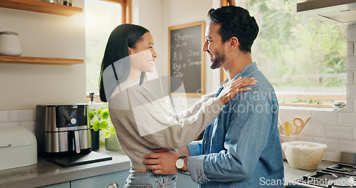 Image of Hug, happy and couple in a kitchen bonding, intimate and talking in their home together with intimacy. Love, face and woman embrace man with smile, care and sharing romantic moment and conversation