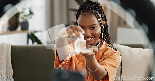 Image of Smile, live streaming and black woman with serum for beauty and open skincare box. Happy, influencer and cosmetics, review product and content creation on social media, ring light and phone at home