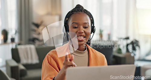 Image of Black woman, headset with laptop and phone call, virtual assistant or crm in home office. Remote work girl at desk with computer, typing and conversation for advice, online chat and help in apartment